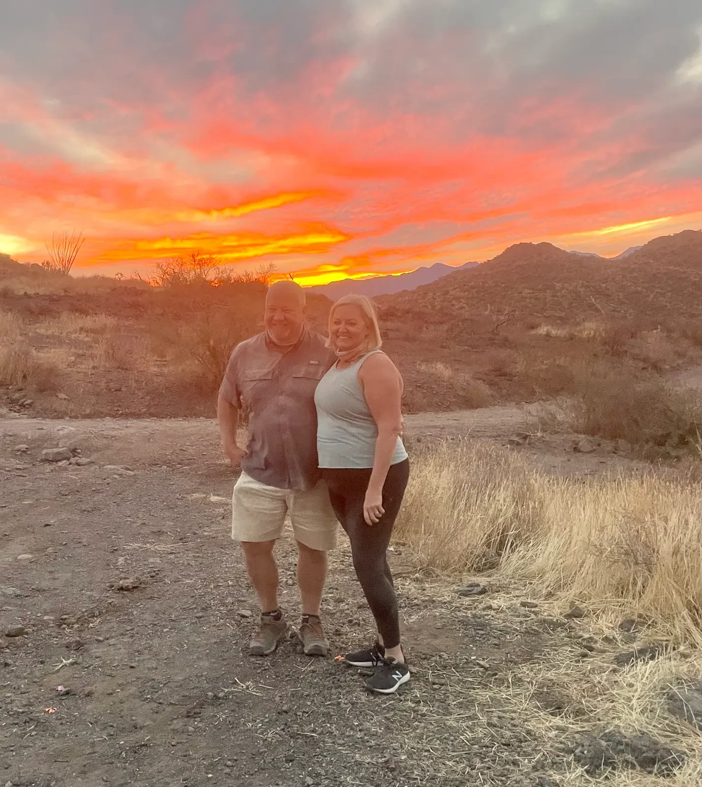 Couple sharing a fiery sunset moment on a Scottsdale sunset dune buggy tour