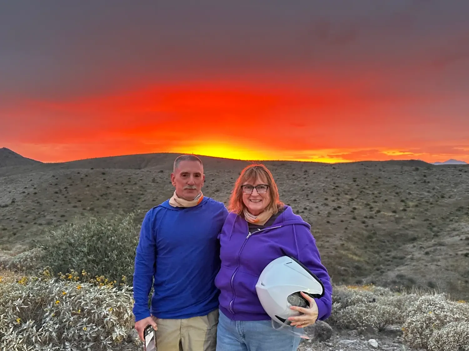 A couple at a vivid red Sonoran Desert sunset on their 360 Adventures tour